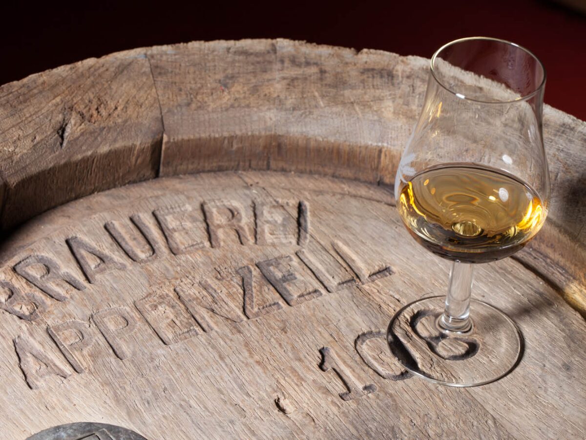 Ein Glas Whisky auf einem Holzfass